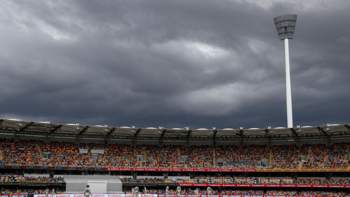 Players watch as rain clouds gather during play on day two of the fourth Test between India and Australia at the Gabba, Brisbane. — AP