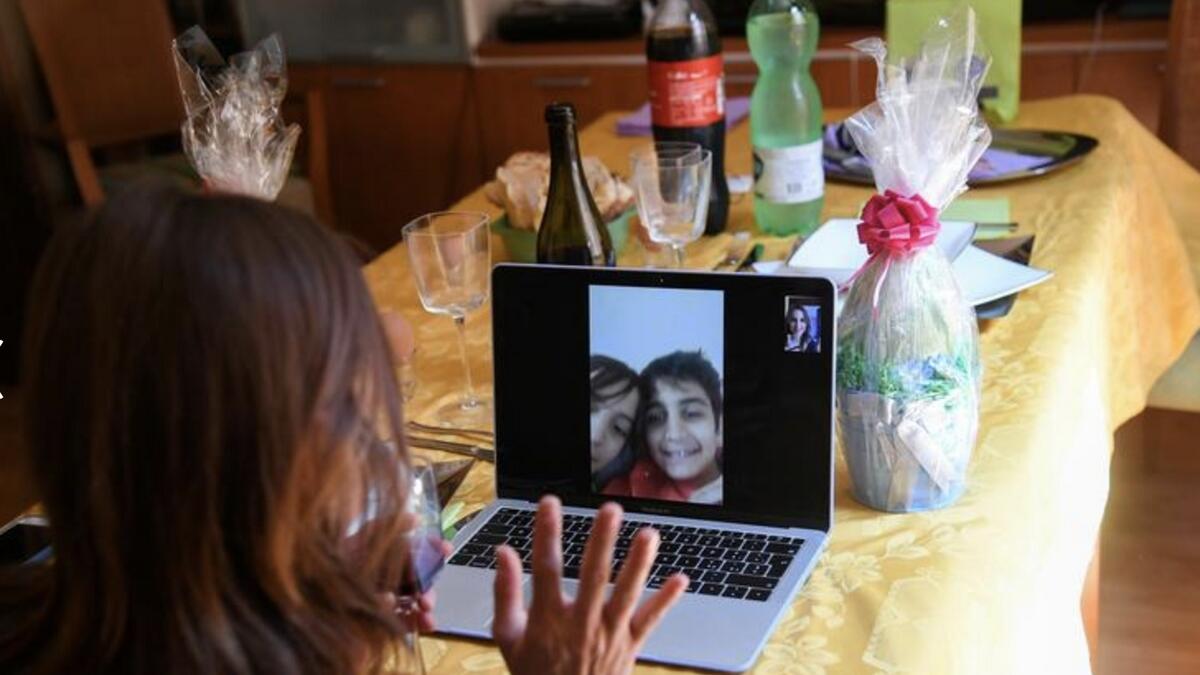 A woman talks with her sons on a video call during an Easter lunch in Rome, Italy. Photo: Reuters