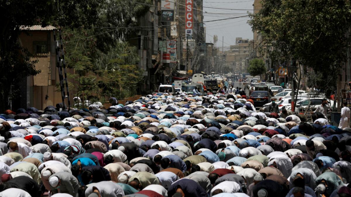 People attend Friday prayers along a road at a business area, after Pakistani authorities re-imposed lockdowns in selected areas in an effort to stop the spread of the coronavirus disease, in Karachi, Pakistan. Photo: Reuters