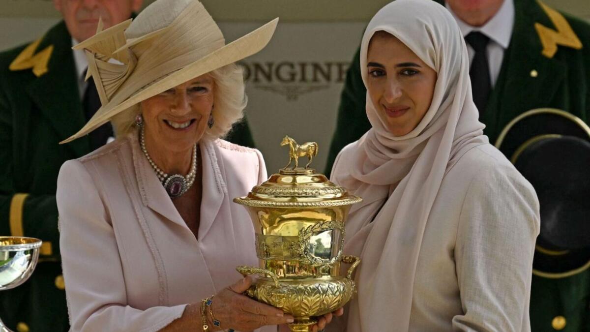 Sheikha Hissa bint Hamdam bin Rashid al-Maktoum receives the Prince Of Wales's Stakes trophy from Britain's Queen Camilla. AFP File