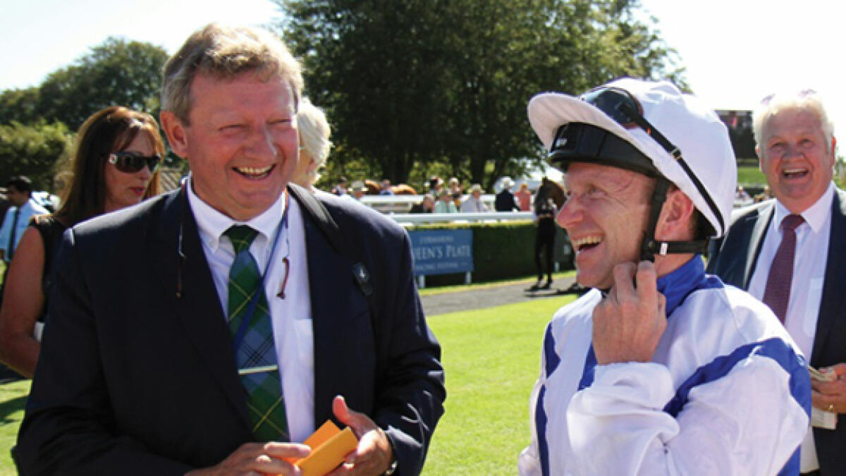Trainer Mark Johnston, shown with jockey Joe Fanning at Glorious Goodwood in 2018, says Royal Ascot will lack something this year. -- AFP