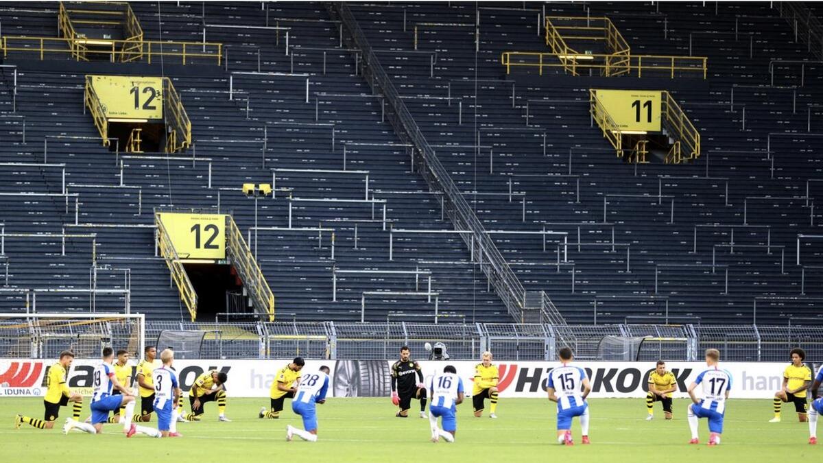 Borussia Dortmund and Hertha players take a knee before the match. - Reuters