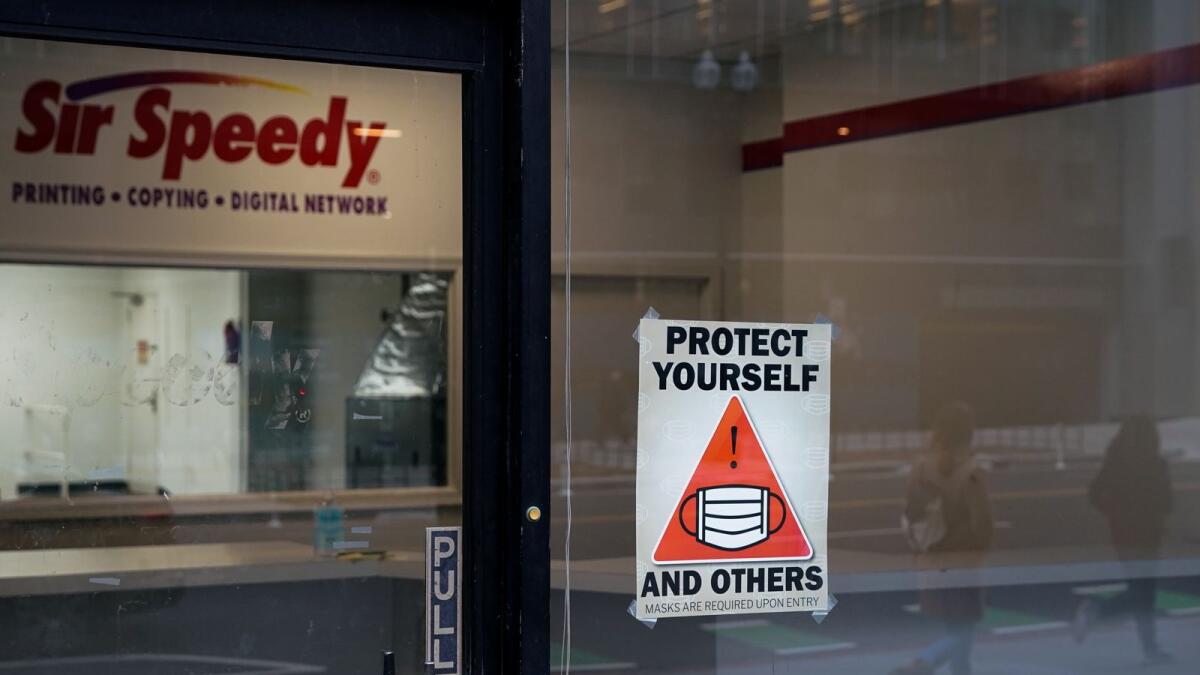 FILE PHOTO: A sign requiring masks is seen outside of a closed-down business during the ongoing coronavirus disease (COVID-19) pandemic in Washington, U.S., December 27, 2021. REUTERS/Elizabeth Frantz