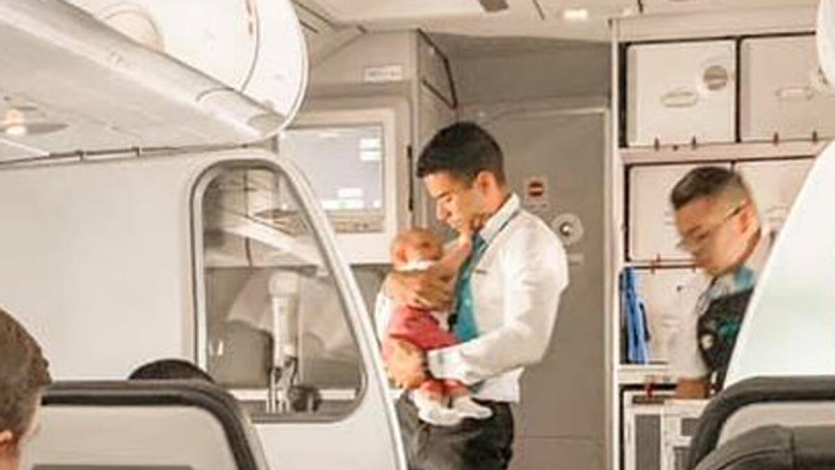Frontier airlines, male flight attendant comforts baby, viral story, viral photos