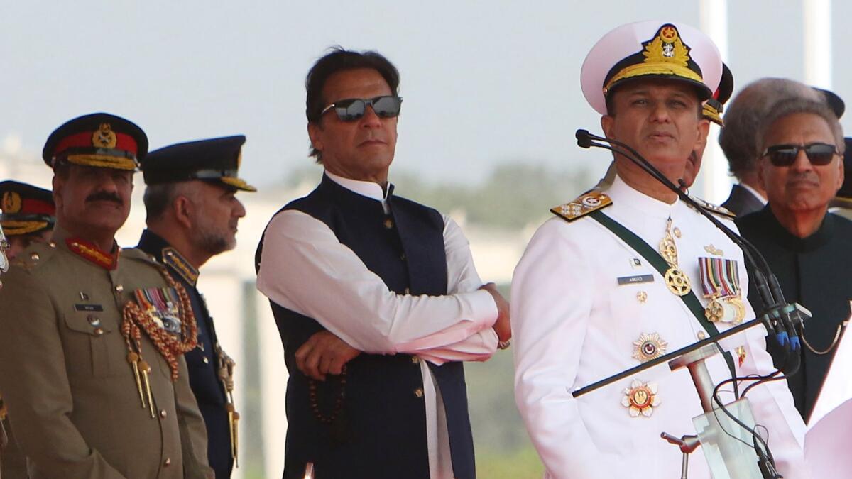 Pakistan's Prime Minister Imran Khan (C) and President Arif Alvi (R) watch Pakistan's Air Force fighter jets perform during the Pakistan Day parade in Islamabad on March 23, 2022. Photo: AFP