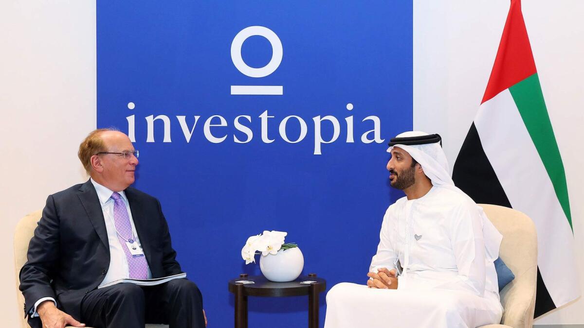 Abdulla bin Touq Al Marri, Minister of Economy, exchanging views with Larry Fink, founder, Chairman and CEO of BlackRock. — Supplied photo