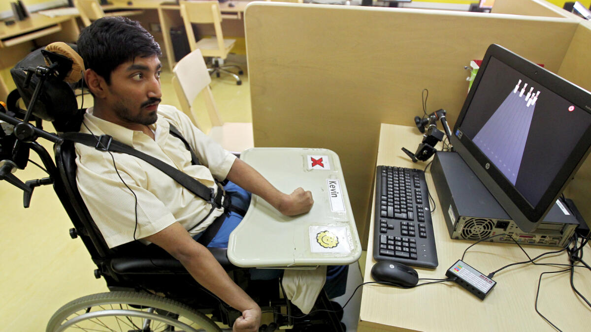 Kevin, the hero,  on his motorised wheelchair and using his head mouse to operate the computer at the Al Noor Centre for Special Needs, Dubai. —Photos by Rahul Gajjar