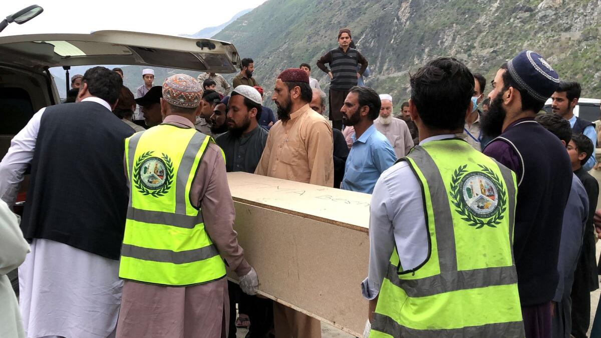 Volunteers transport the coffins of Chinese national from a hospital following a suicide attack in Besham city in the Shangla district of Khyber Pakhtunkhwa province last month. — AFP