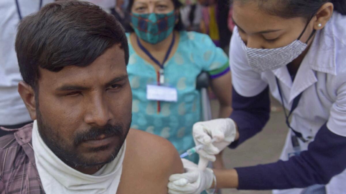 A visually impaired man receives a dose of the Covishield vaccine at a vaccination camp in Ahmedabad. — AFP