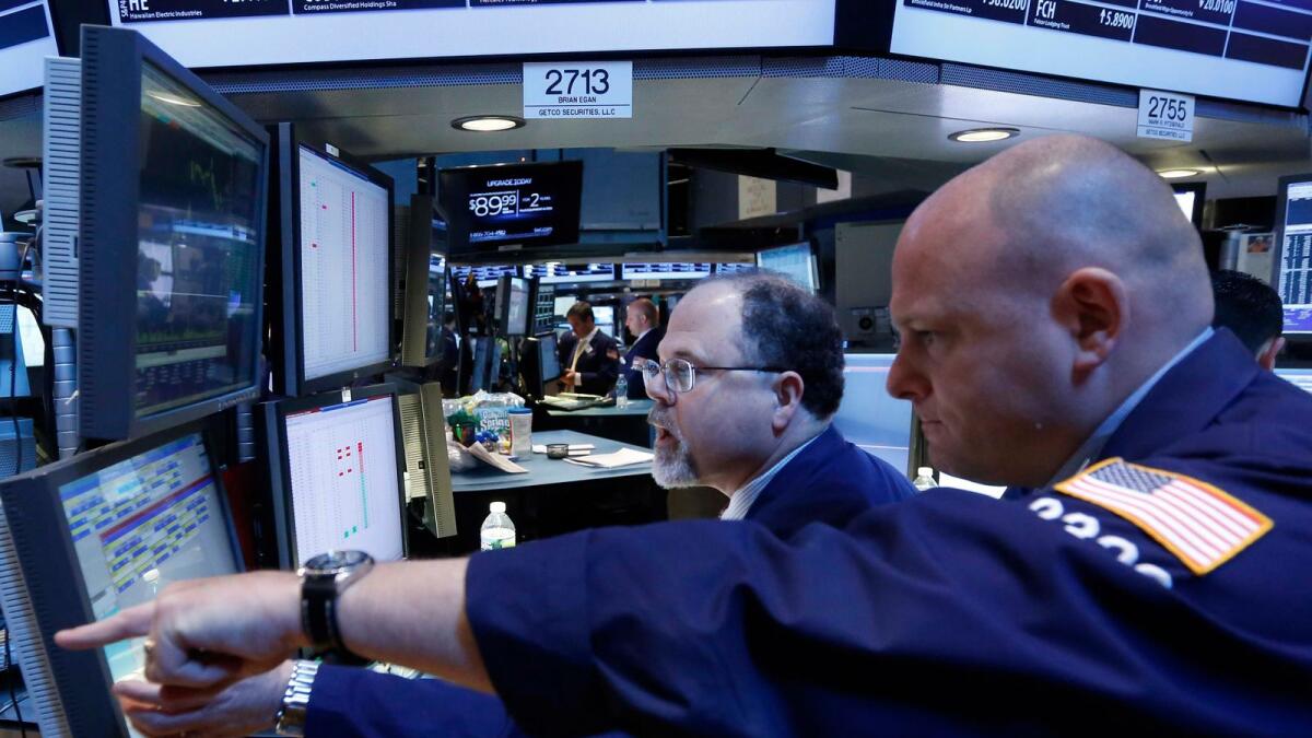 Getco Securities Specialist traders work at a post on the floor at the New York Stock Exchange. -- Reuters file photo