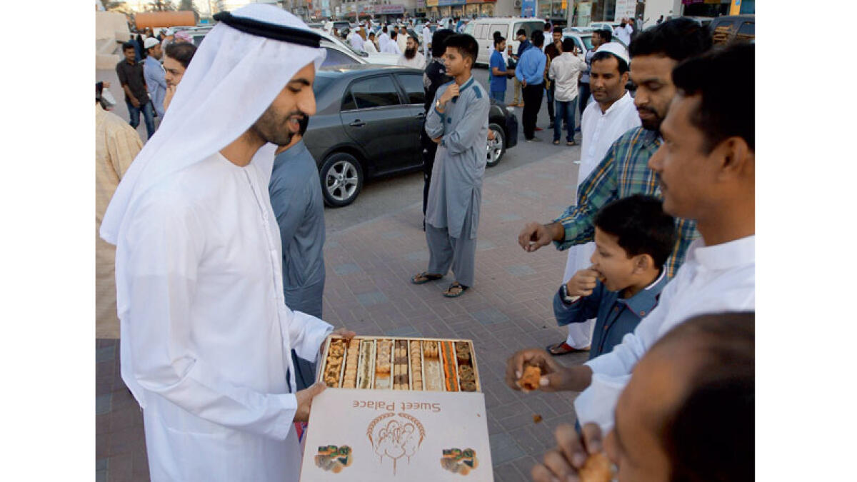 DAY FOR SWEETS ... An Emirati distributes sweets after offering prayer at the King Faisal Mosque in Sharjah.