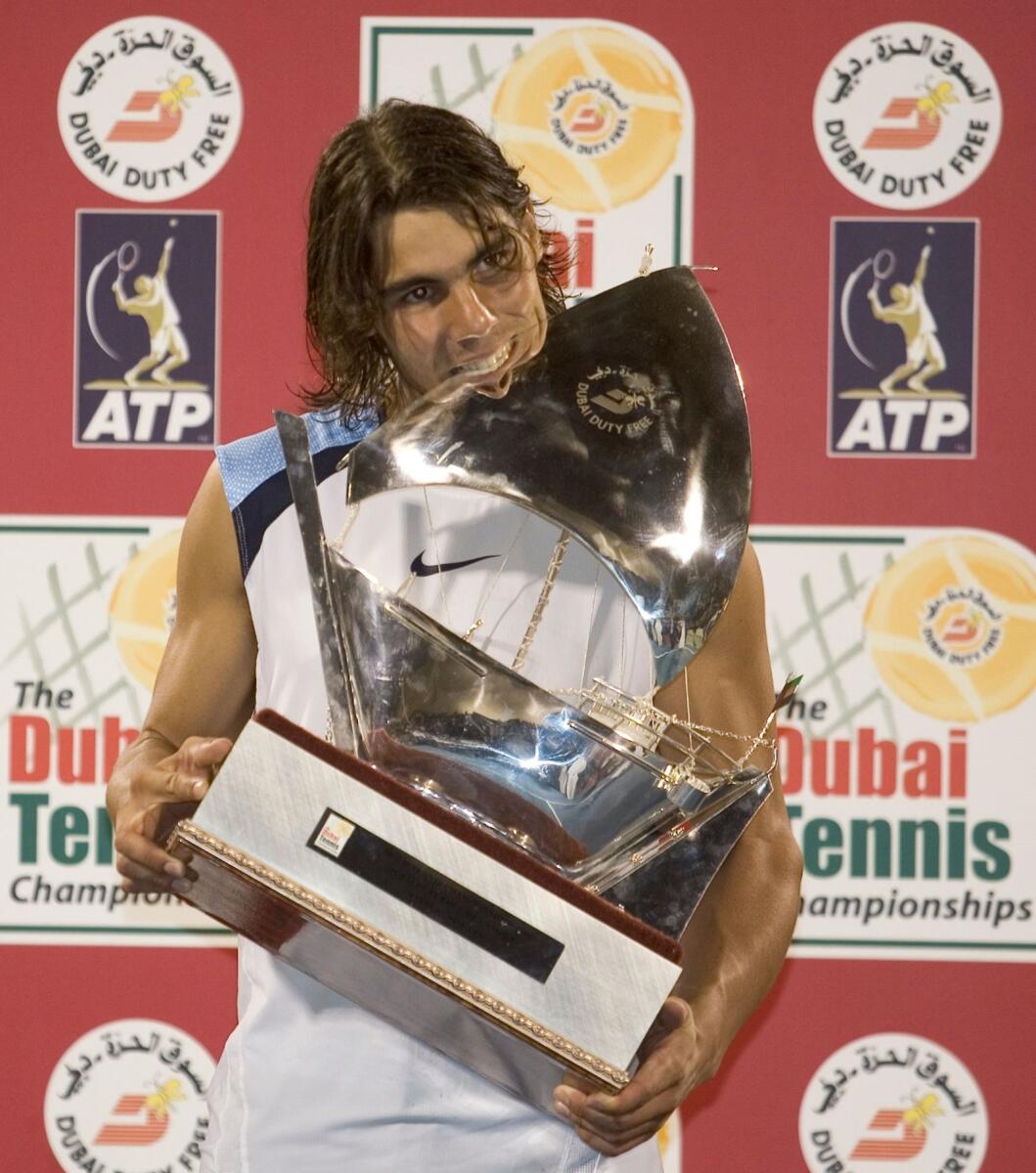 Rafael Nadal celebrates with the trophy after winning the Dubai tournament in 2006. — KT file