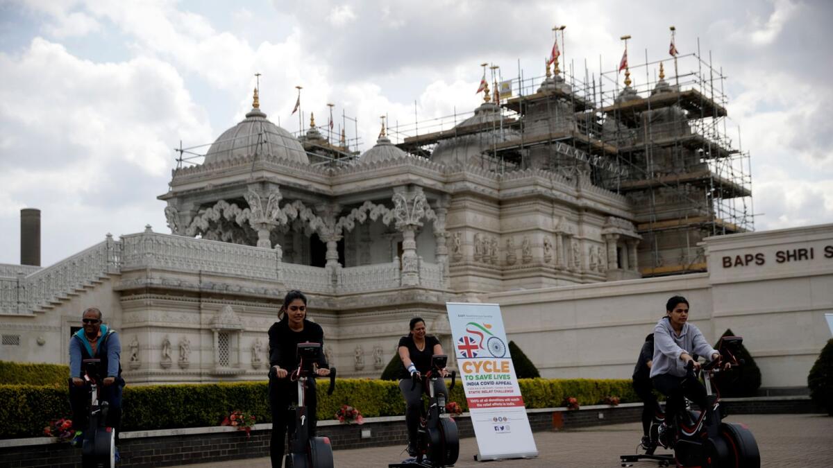 People take part in 'Cycle to Save Lives' a 48-hour, non-stop static relay cycle challenge at the BAPS Shri Swaminarayan Mandir in north London to raise money to help coronavirus relief efforts in India on Saturday.