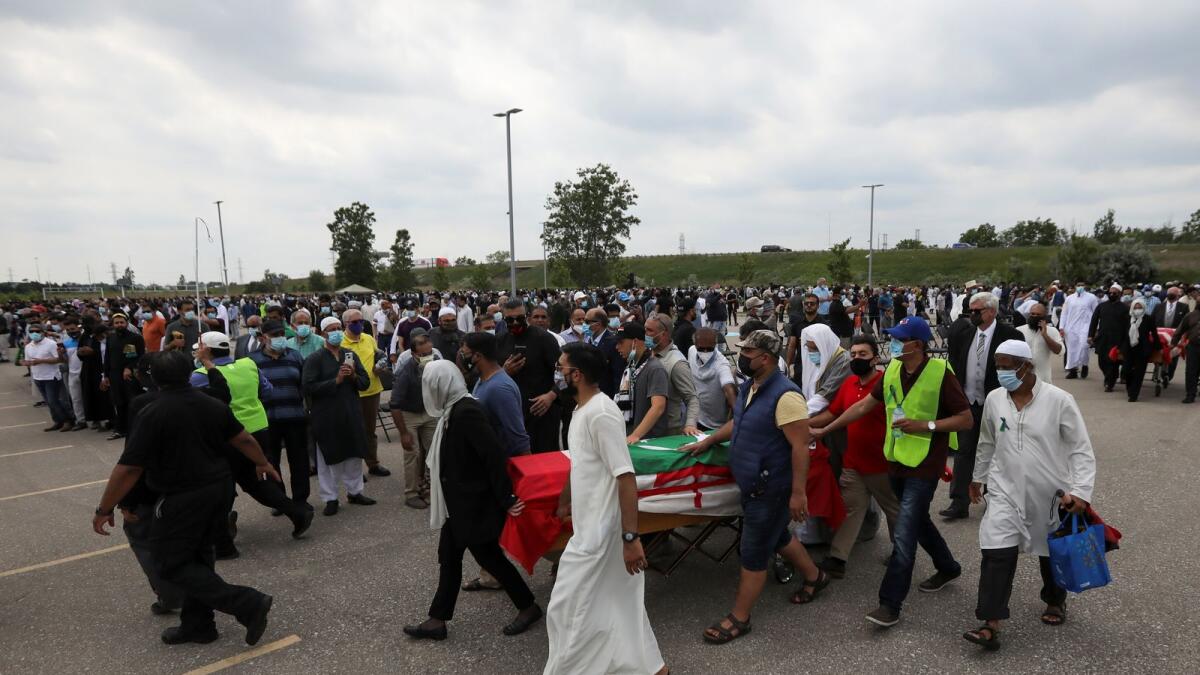 People transport a flag-wrapped coffin, outside the Islamic Centre of Southwest Ontario, during a funeral of the Afzaal family that was killed in what police describe as a hate-motivated attack, in London, Ontario, Canada, on Saturday.