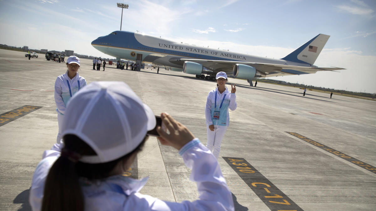 A Chinese volunteer poses for a photo in front of Air Force One after U.S. President Barack Obama arrived at the Hangzhou Xiaoshan International Airport, Saturday, Sept. 3, 2016, in Hangzhou, China, to attend the G-20 summit. Obama is expected to meet with China's President Xi Jinping Saturday afternoon. (AP Photo/Mark Schiefelbein)