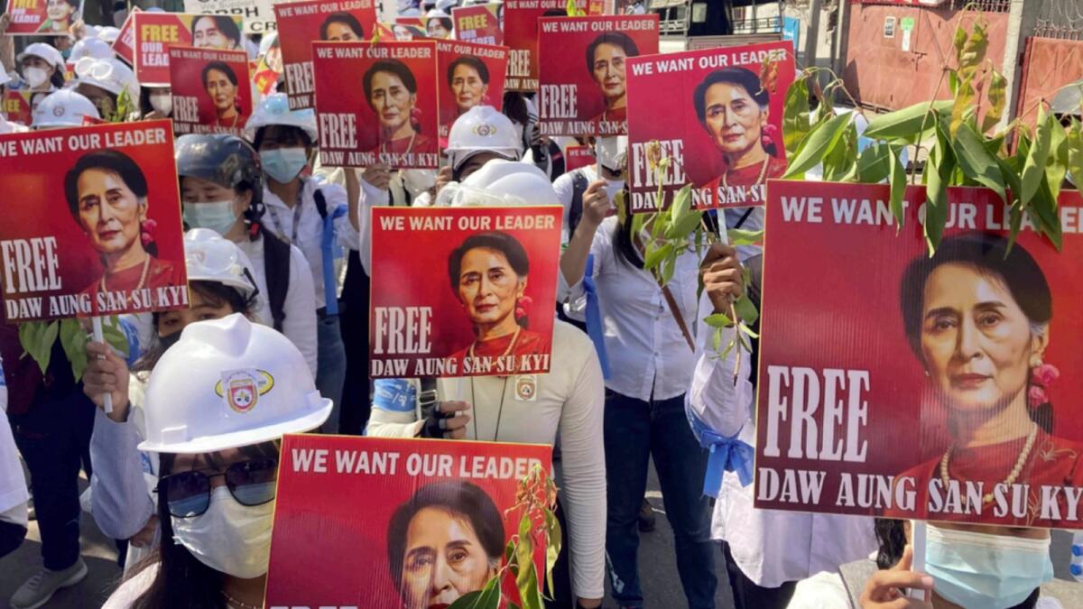 Protesters hold portraits of deposed Myanmar leader Aung San Suu Kyi during an anti-coup demonstration in Mandalay. — AP file