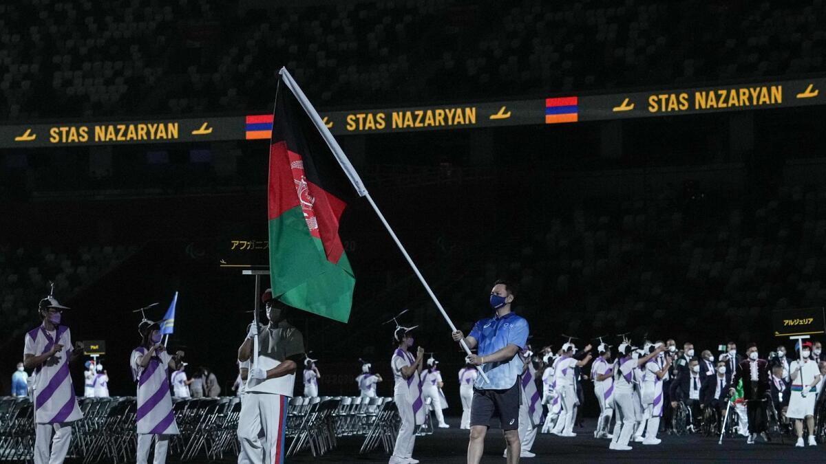 A volunteer carries the flag of Afghanistan at the opening ceremony for the  2020 Paralympic Games in Tokyo. (AFP)