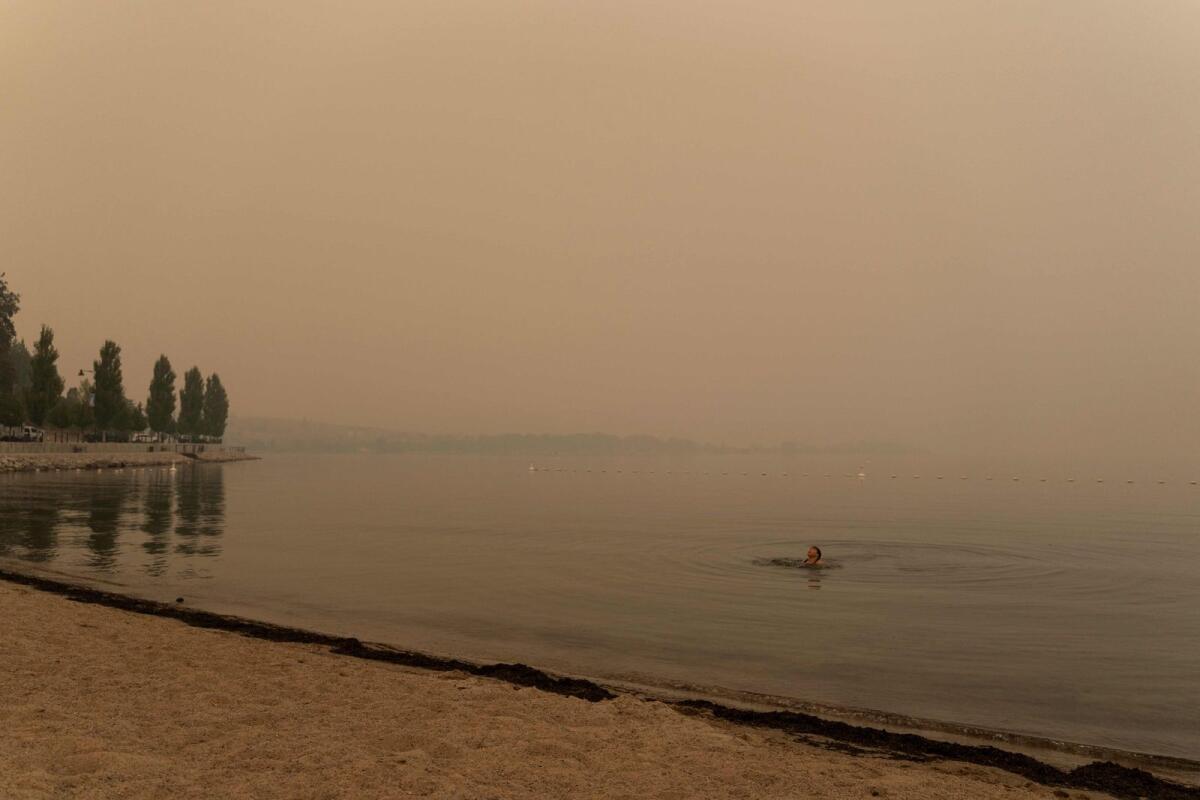 Sarah Sokoloski 20, swims in Lake Okanagan covered in wildfires smoke in West Kelowna, British Columbia on August 19, 2023. — AFP