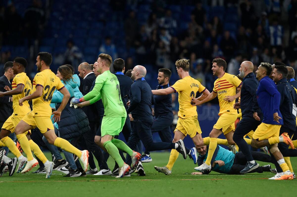 Barcelona players leave the pitch in a hurry as Espanyol fans invade the pitch after the Spanish league match. — AFP
