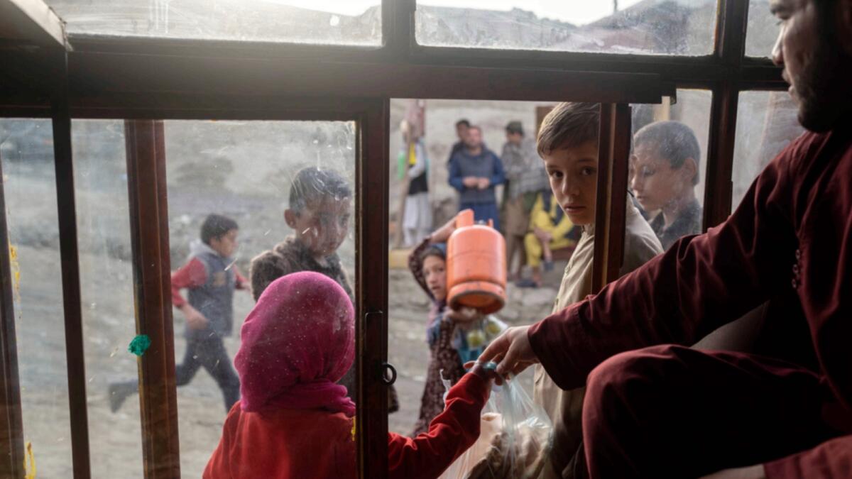 Afghan children buy bread from a bakery in Kabul. — AP file