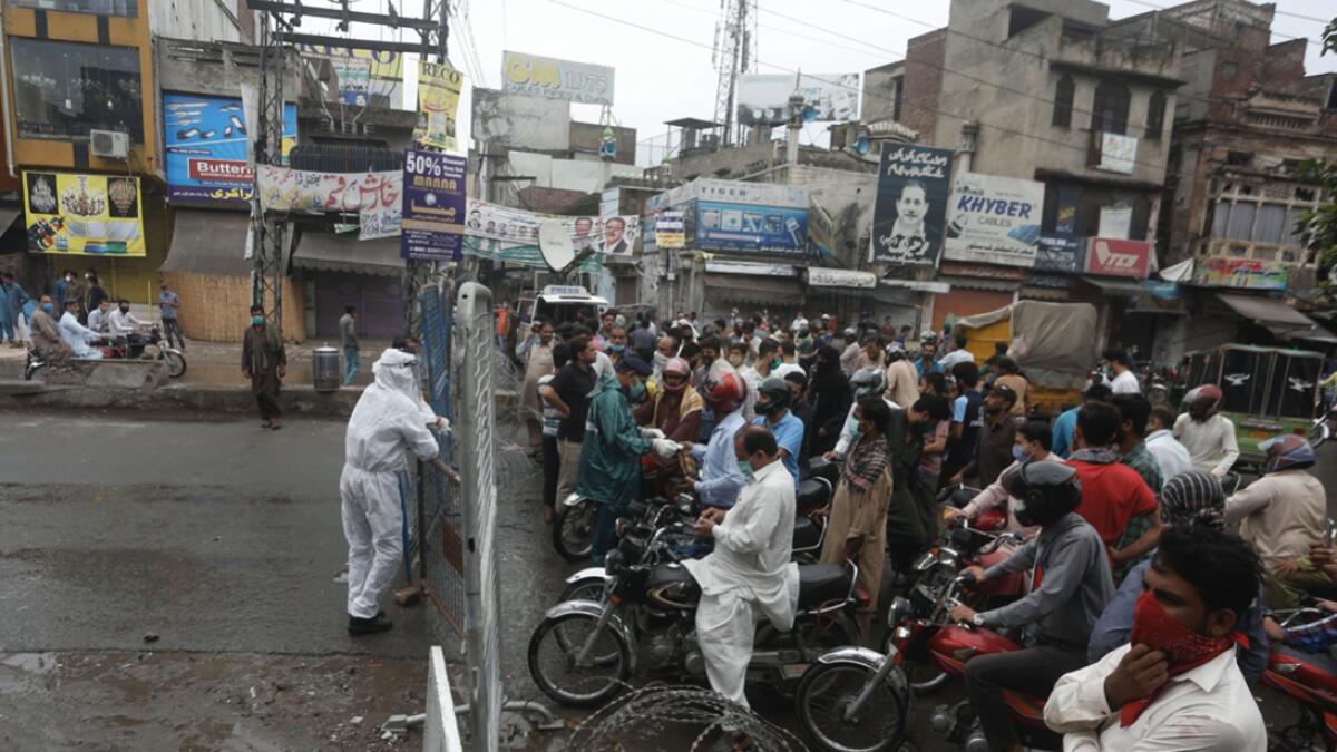 Police officers stop motorcyclists from entering a restricted area that is sealed off to control the spread of the coronavirus, in Lahore, Pakistan. Photo: AP