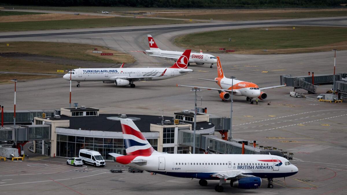 This photograph taken in Geneva on July 28, 2022 shows planes of carriers British Airways, Swiss International Air Lines, EasyJet and Turkish Airlines seen from the Geneva Airport air traffic control. British Airways-owner IAG on Friday returned to profit for the first time since the outbreak of the Covid-19 pandemic as demand for European flights between April and June boosted its battered finances. — AFP