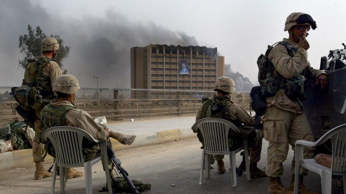 American troops watch as the Ministry of Transportation building burned in Baghdad in April 9, 2003. In the 20 years since the United States invaded Iraq, Iran has built up loyal militias inside Iraq, gained deep political influence in the country and reaped economic benefits; for Washington, these were unintended consequences. (Tyler Hicks/The New York Times)