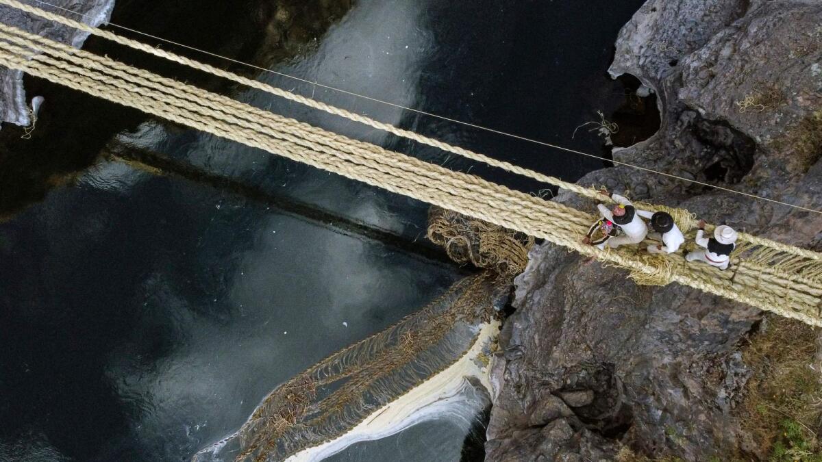 Aerial view showing people from different communities participating in the annual renovation of the Q'eswachaka rope bridge, as the old one drifts away in the Apurimac river, near Huinchiri, Quehue District, Cusco Department, in southern Peru, on June 9, 2023.  — AFP