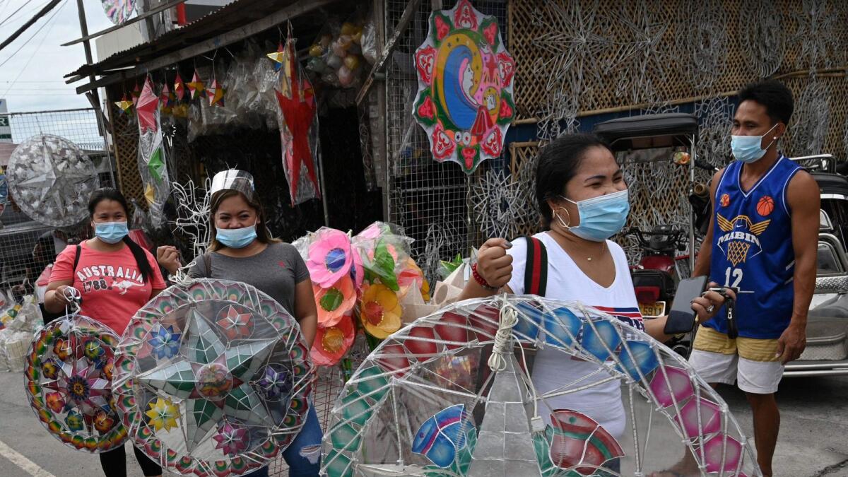 Customers walking away with newly-purchased lanterns for the festive season in San Fernando town in Pampanga province.