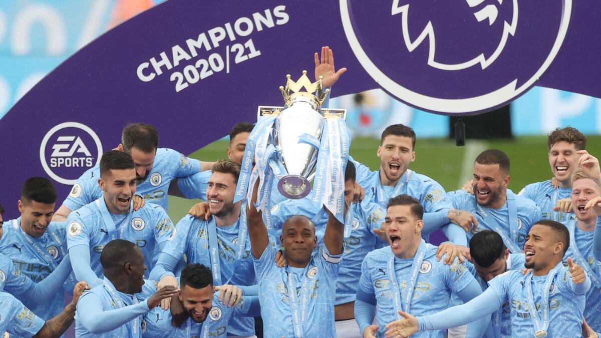 Manchester City's Fernandinho lifts the trophy as they celebrate winning the Premier League. — Reuters