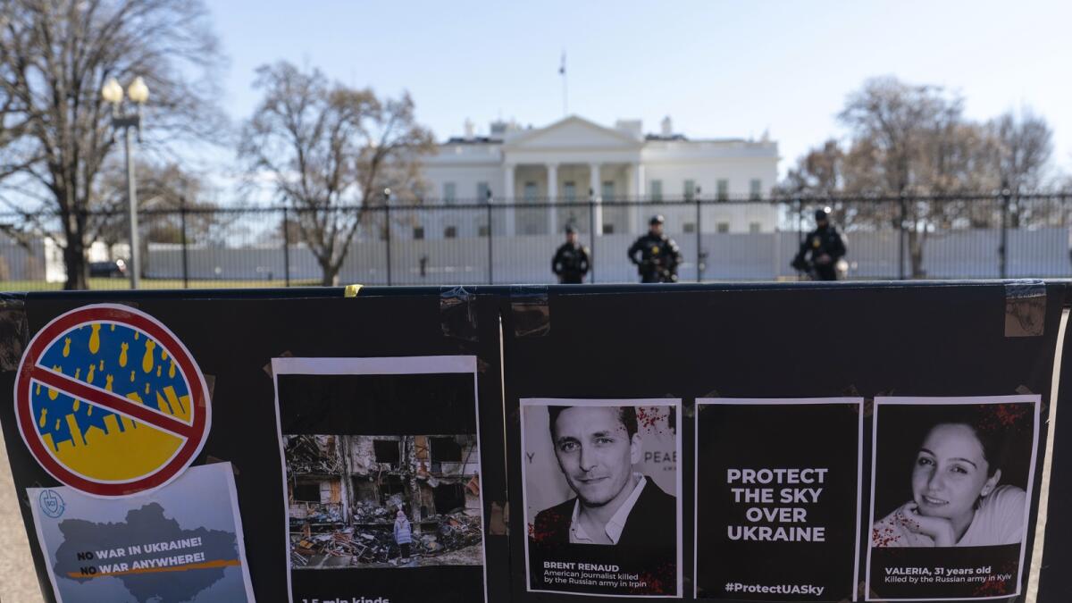 Signs and pictures of those killed, including journalist Brent Renaud, are displayed on a fence during a protest against Russia's attack on Ukraine in Lafayette Park near the White House on March 13, 2022, in Washington. — AP file
