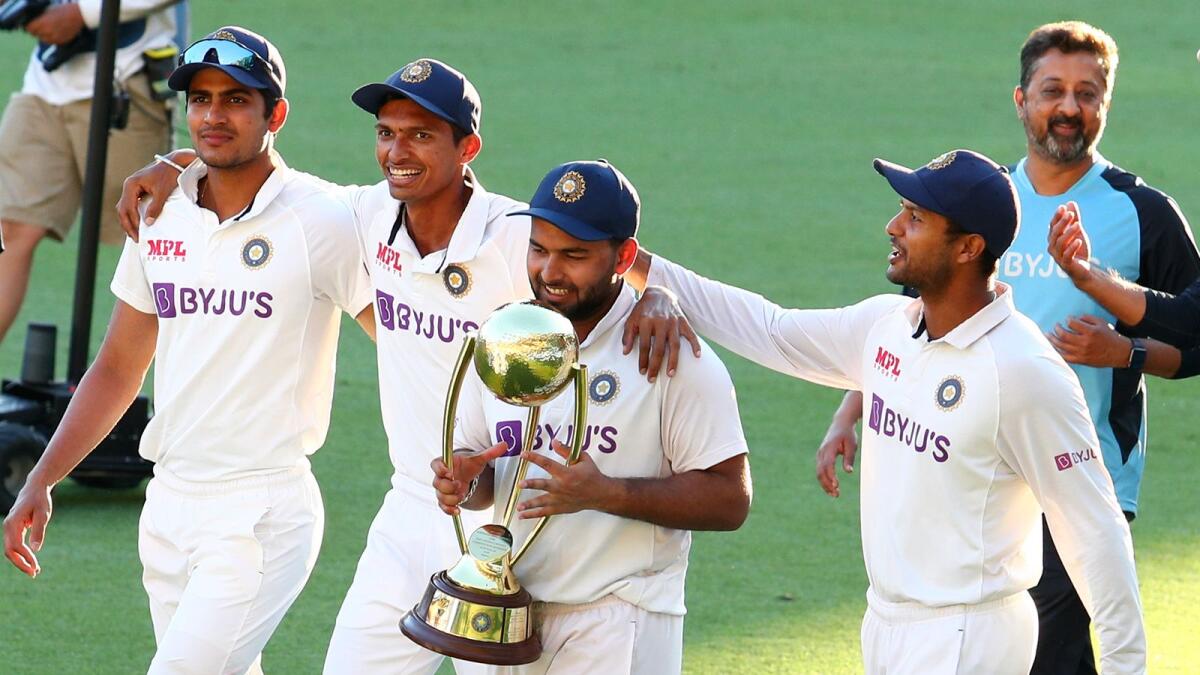 India's Rishabh Pant carries the trophy as he celebrates with his teammates after defeating Australia by three wickets in Brisbane Test. — AP