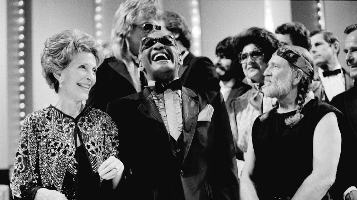 First lady Nancy Reagan, left, gets a laugh with Ray Charles, center, and Willie Nelson, right, and other entertainers at a salute to country music at Constitution Hall in Washington. -AP file photo