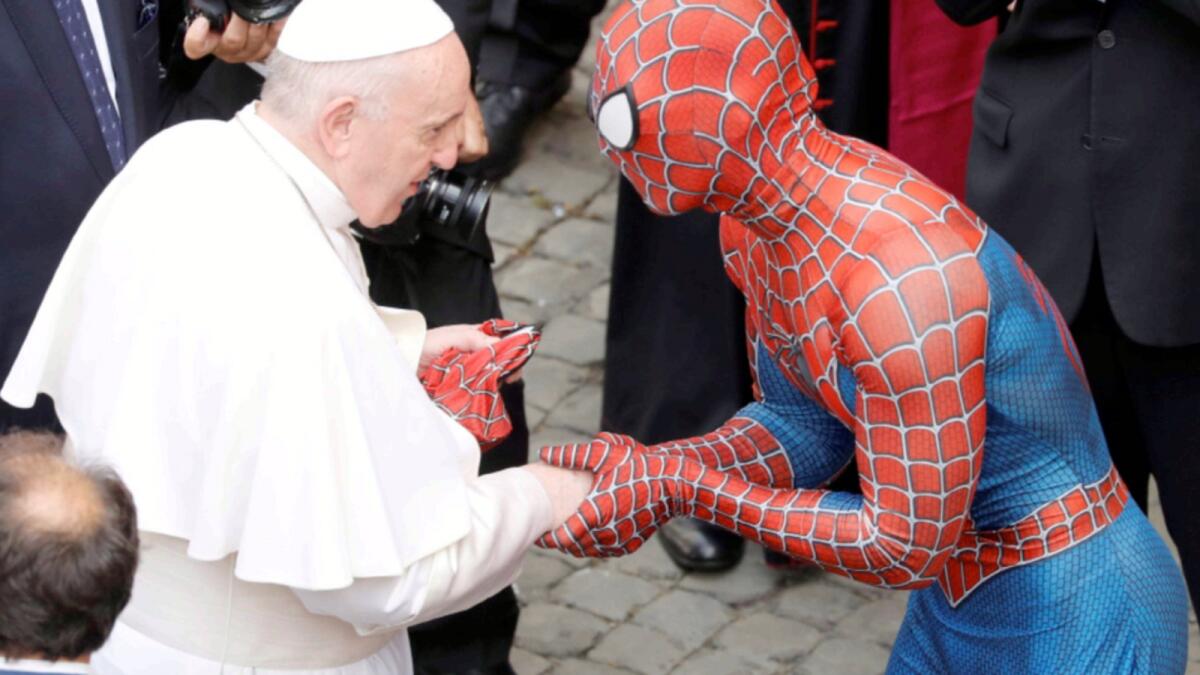 Pope Francis receives a Spider-Man mask from a person dressed as Spider-Man after the general audience at the Vatican. — Reuters