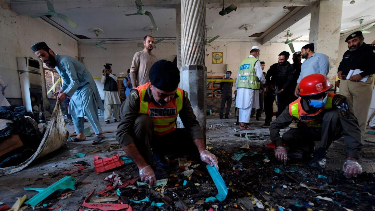 Security officials examine the site of a blast at a religious school in Peshawar on October 27, 2020. AFP