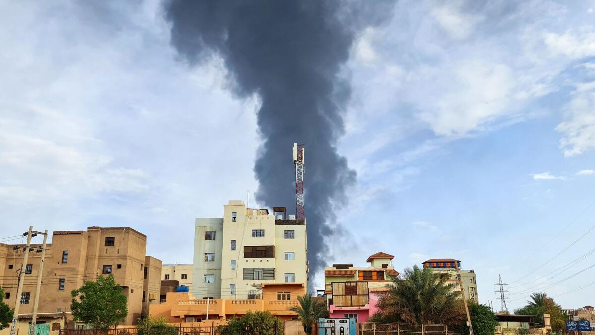 Black smoke billows behind buildings amid ongoing fighting in Khartoum. — AFP