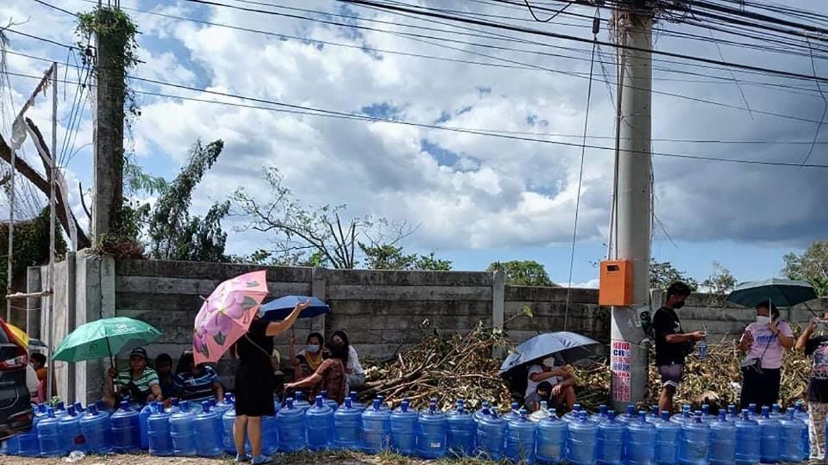 Residents with their water plastic containers queue up to fetch water along a road in Tagbilaran City, Bohol province. Photo: AFP