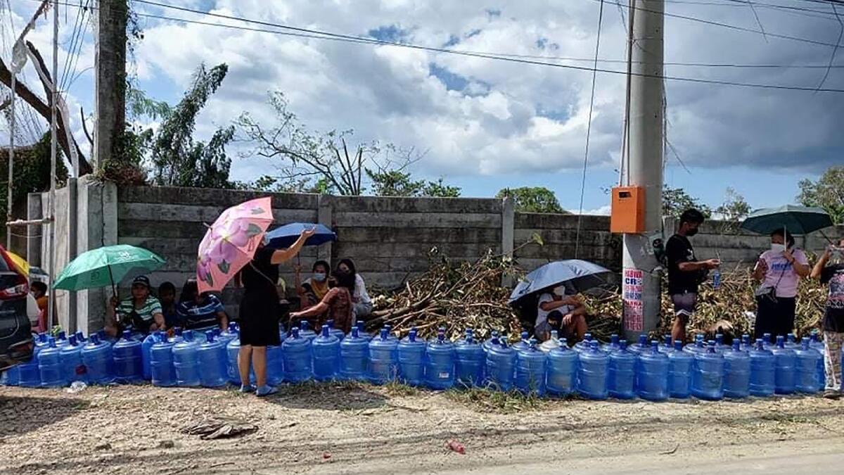 Residents with their water plastic containers queue up to fetch water along a road in Tagbilaran City, Bohol province. Photo: AFP