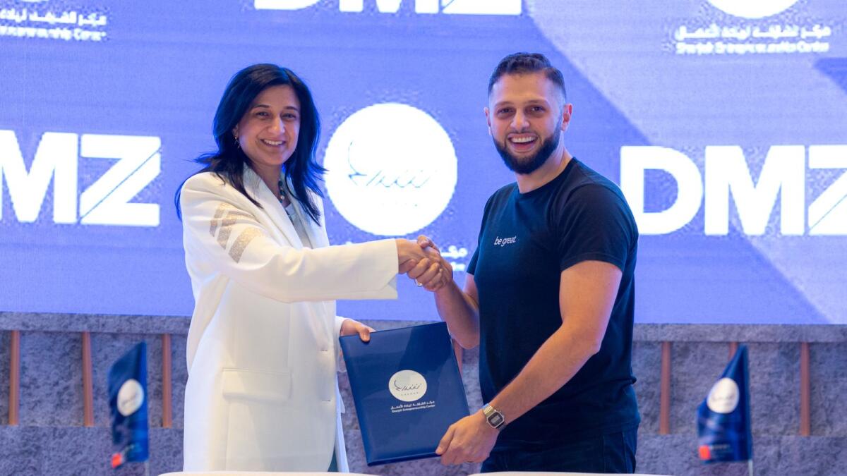 Najla Al Midfa, CEO of Sheraa, and Abdullah Snobar, executive director of the DMZ and CEO of DMZ Ventures, shake hands after signing the agreement. — Supplied photo