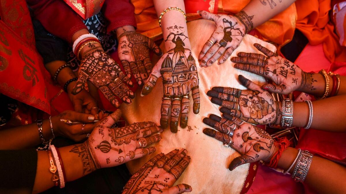 Young women display 'mehndi' on their palm during a celebration ahead of the consecration ceremony of Ram Mandir, in Ayodhya, in Kolkata on Saturday. Photo: PTI