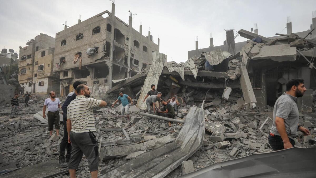 Palestinians search for survivors of Israeli aerial bombing on Jabaliya, near Gaza City on October 11. — AP