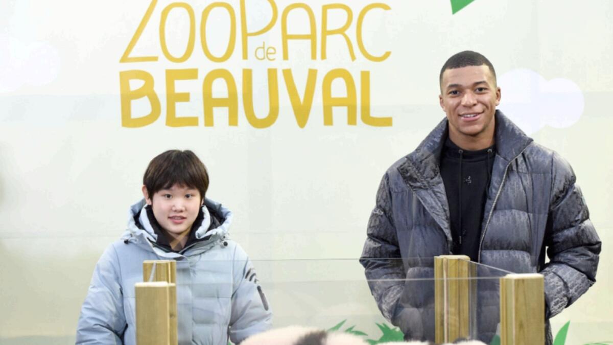 Kylian Mbappe and Zhang Jiaqi pose with the panda cubs, named Yuandudu and Huanlili, at Beauval Zoo. — AFP