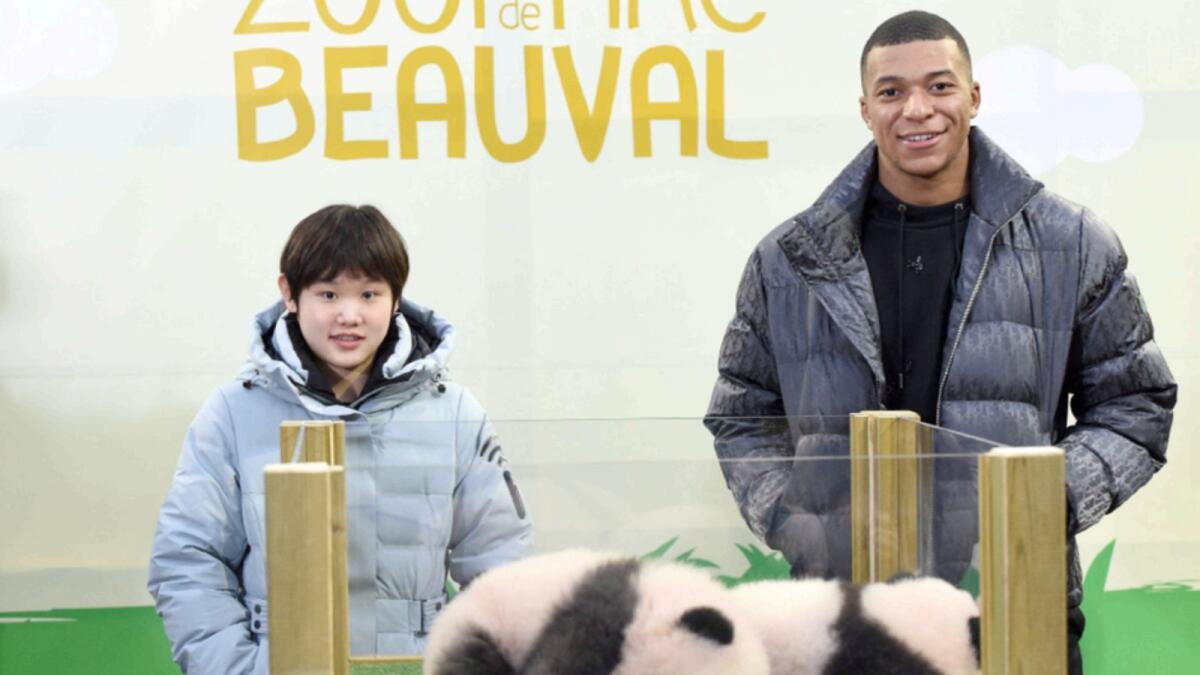 Kylian Mbappe and Zhang Jiaqi pose with the panda cubs, named Yuandudu and Huanlili, at Beauval Zoo. — AFP