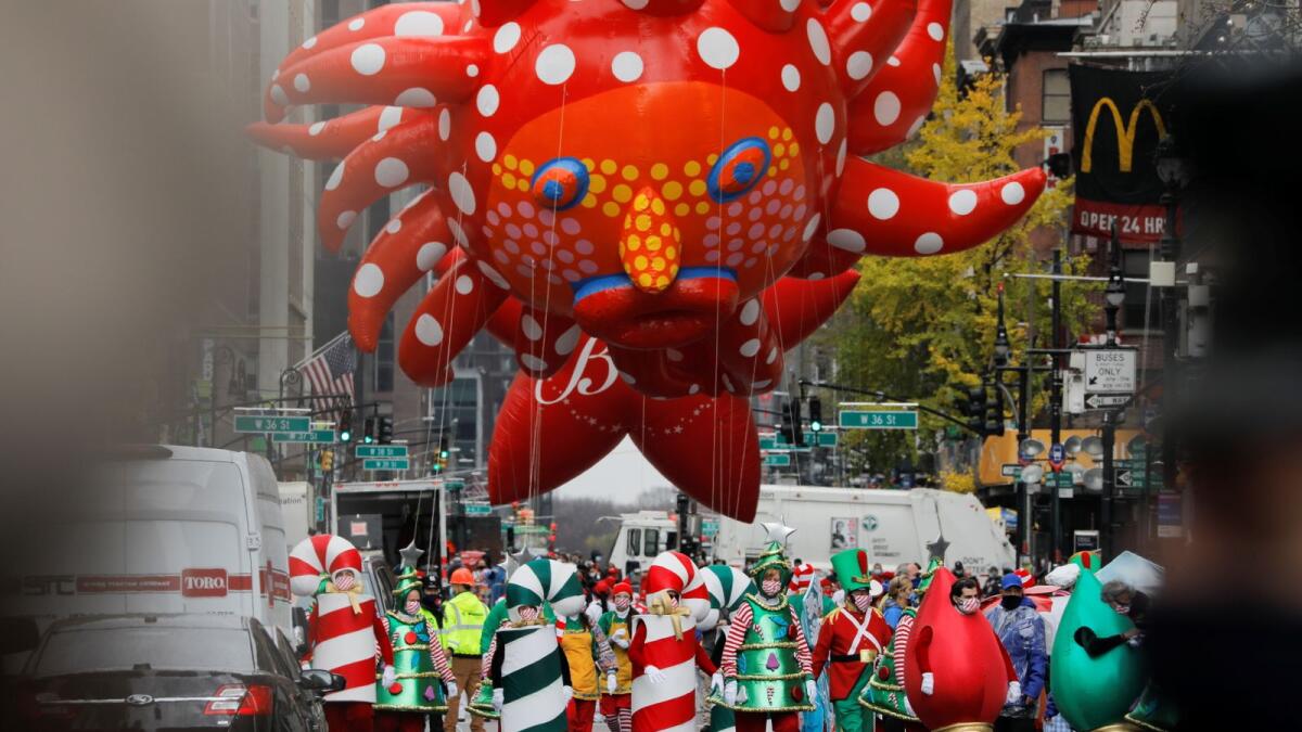 Assistants carry Yayoi Kusama's 'Love Flies Up to the Sky' balloon during the 94th Macy's Thanksgiving Day Parade closed to the spectators due to the spread of the coronavirus disease (COVID-19), in Manhattan, New York City, U.S., November 26, 2020.