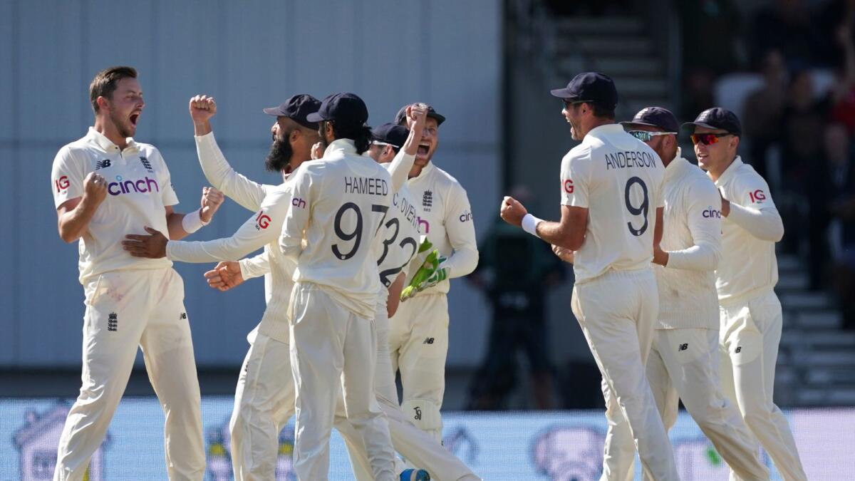 England's Ollie Robinson (left) and teammates celebrate the dismissal of India's Cheteshwar Pujara during the fourth day of third Test.— AP