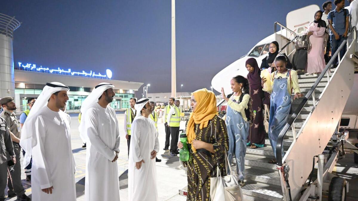 Officials receive people arrived in the UAE in an evacuation plane from Sudan on Friday. — Wam