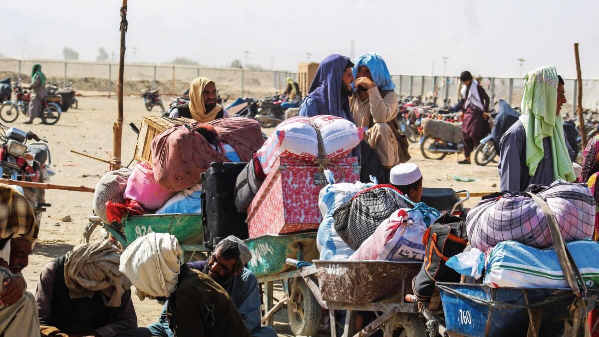 People sit with their belongings in the Pakistan side of the border after the authorities of Pakistan and Afghanistan close the movement of people across the border, in Chaman on September 30, 2021.-AFP FILE