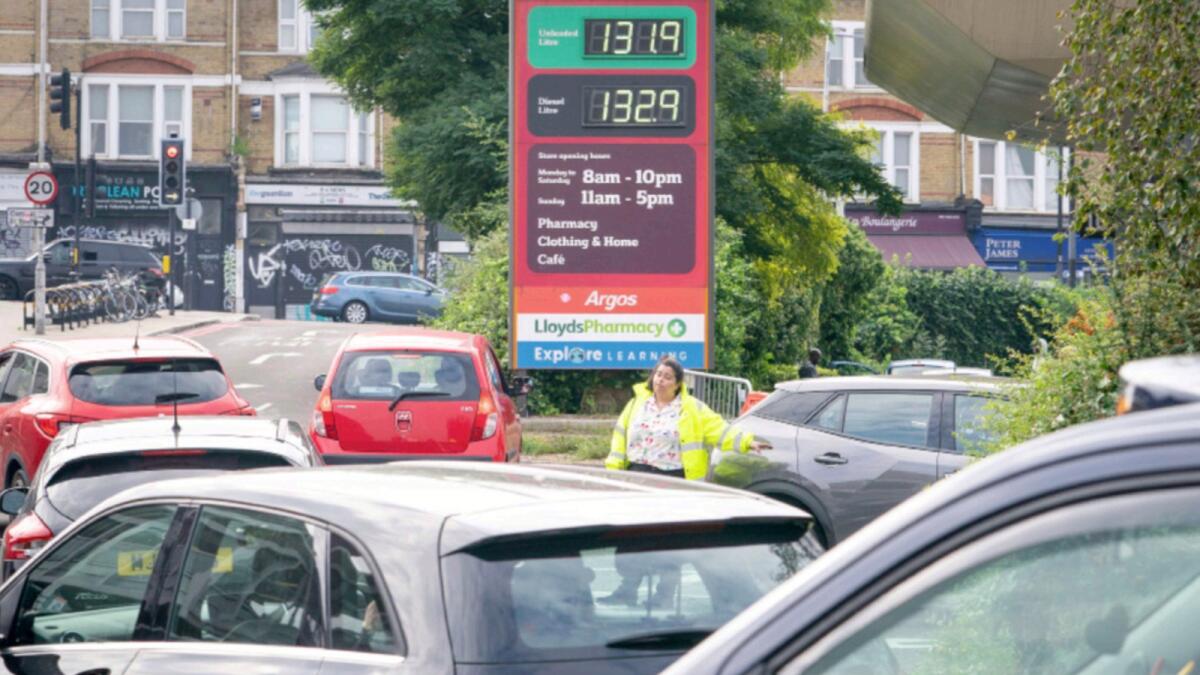 A member of staff directs drivers in a queue for fuel at a closed Sainsbury's petrol station in south London. — AP