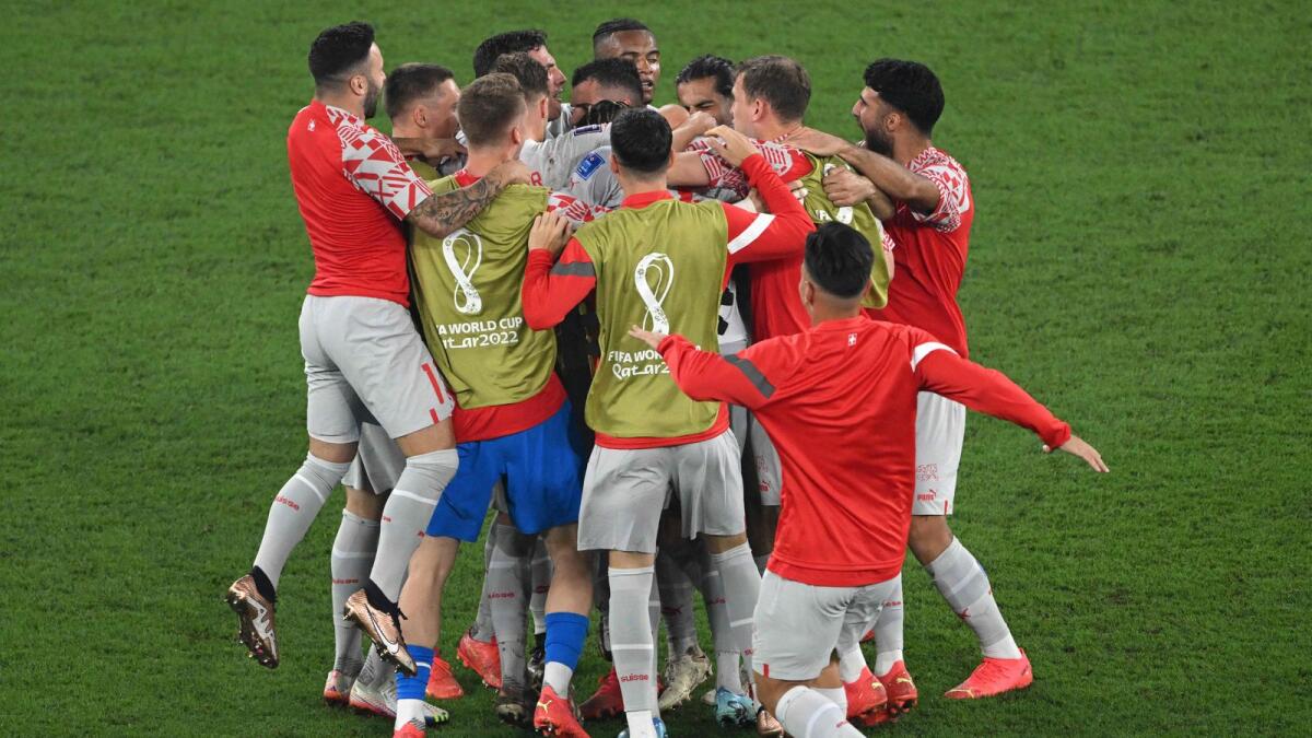 Players of Switzerland celebrate after defeating Serbia 3-2 and qualifying to the next round of the tournament, at the end of the Qatar 2022 World Cup Group G football match between Serbia and Switzerland. - AFP