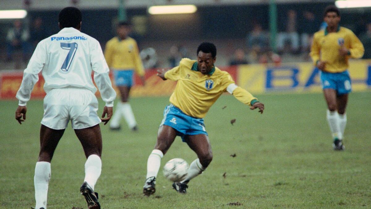 Pele plays the ball during a friendly soccer match opposing Brazil to celebrate his fiftieth birtday in Milan. AFP